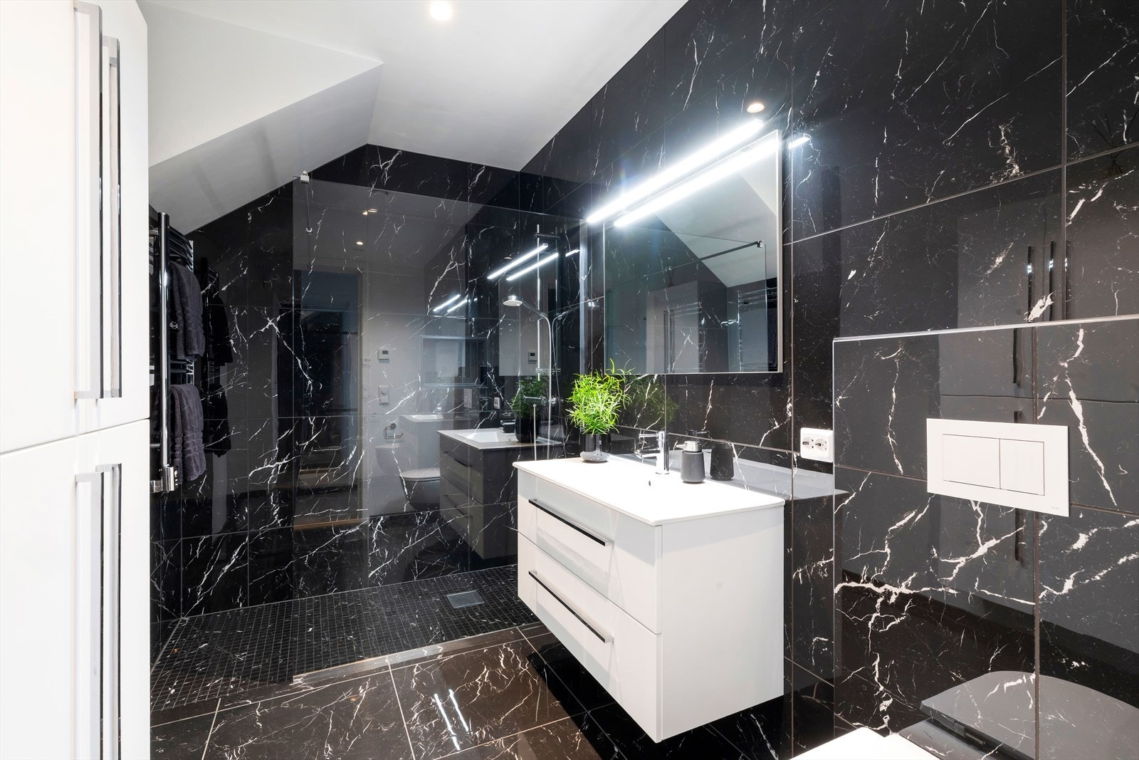 Baderommet er tilknyttet gangen og er lekkert flislagt. Galleribilde