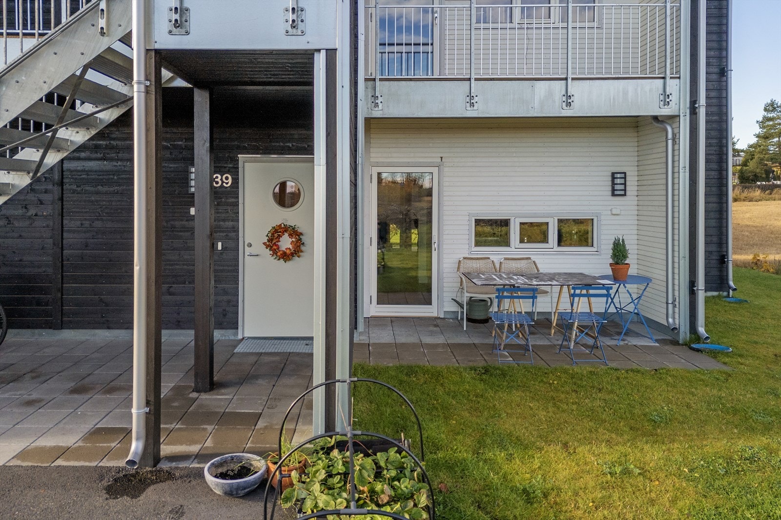 Overbygget inngangsparti, og hellelagt uteplass. Galleribilde