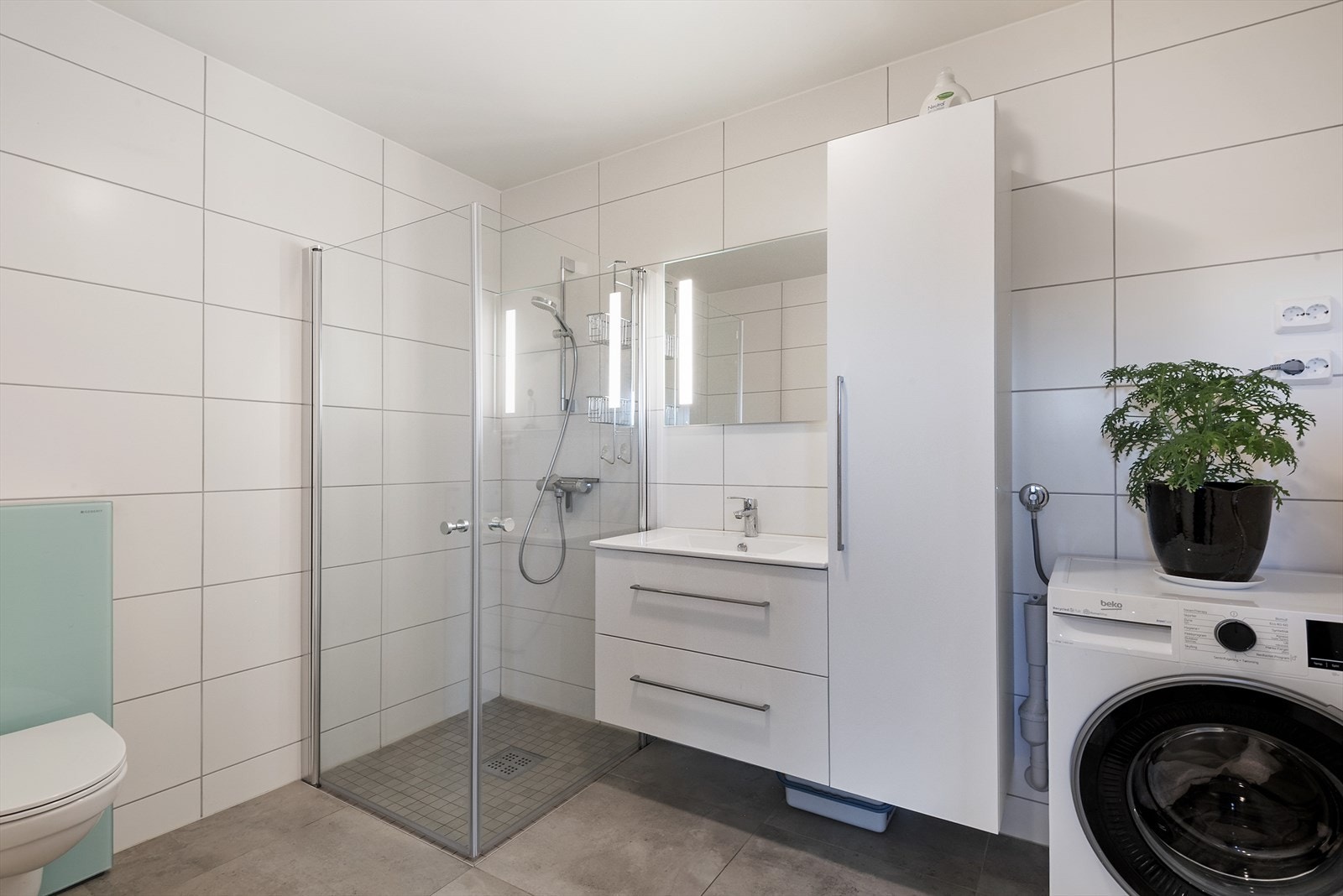 Bad med lys innredning og dusj, samt plass til vaskemaskin. Galleribilde
