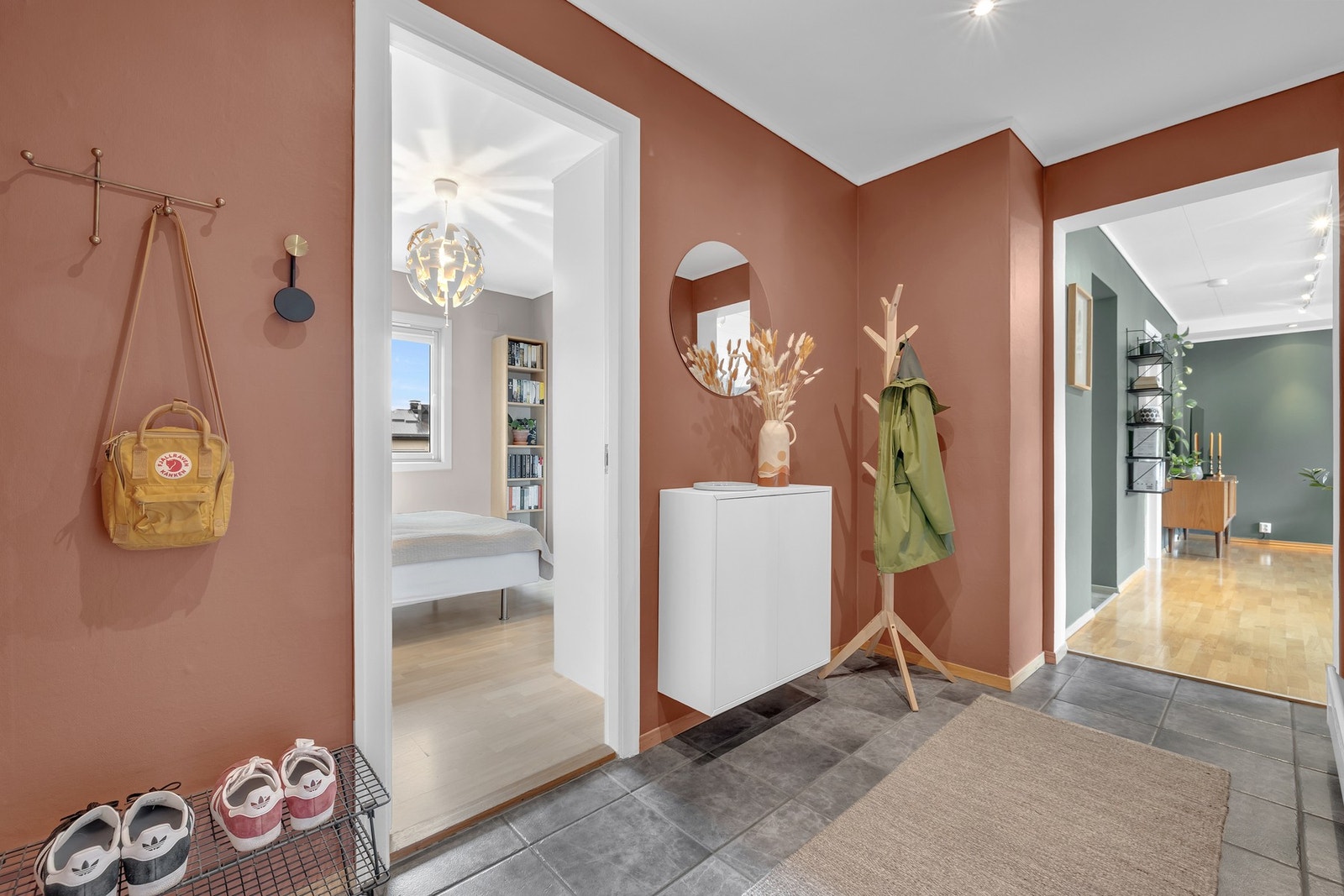 Romslig, flislagt entré med god plass til oppbevaring av sko og yttertøy. Galleribilde