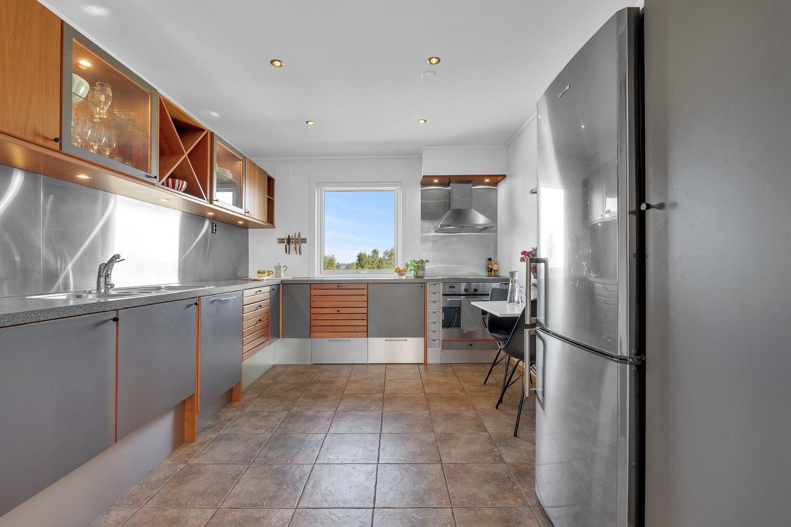 Stort og innbydende kjøkken med flislagt gulv, funksjonell innredning og en hyggelig spiseplass. Galleribilde