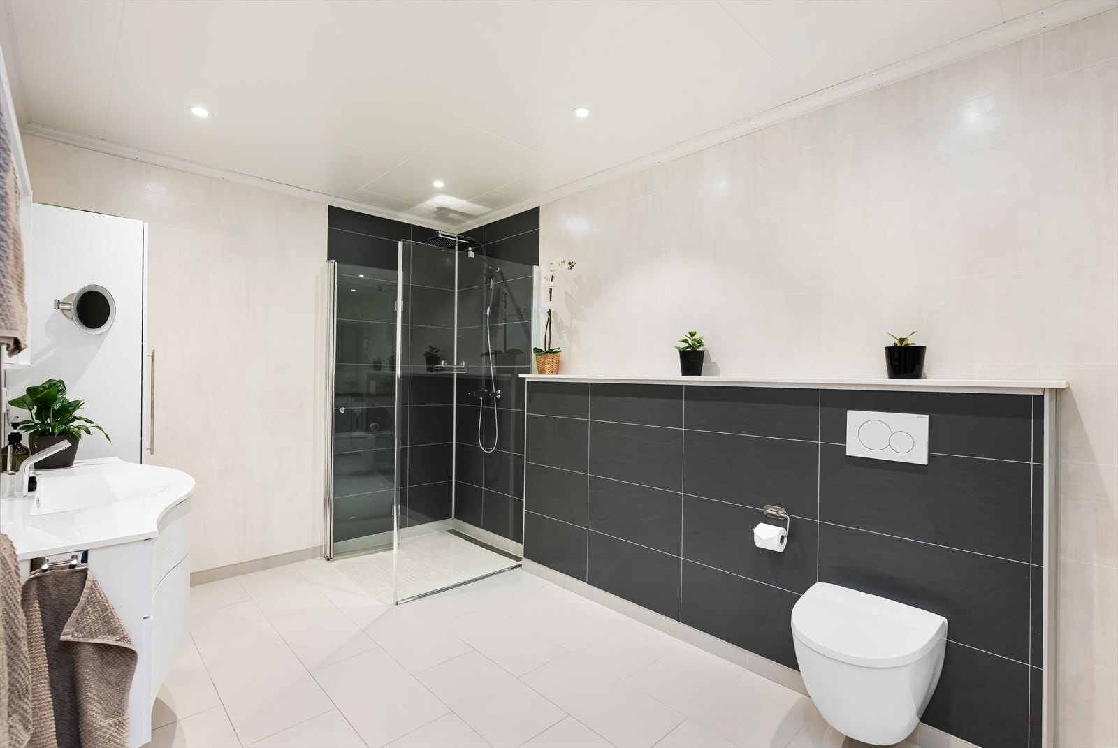 Rommet er virkelig innholdsrikt med en lekker lys baderomsinnredning med heldekkende servant, håndkletørker, vegghengt toalett og dusjhjørne. Galleribilde