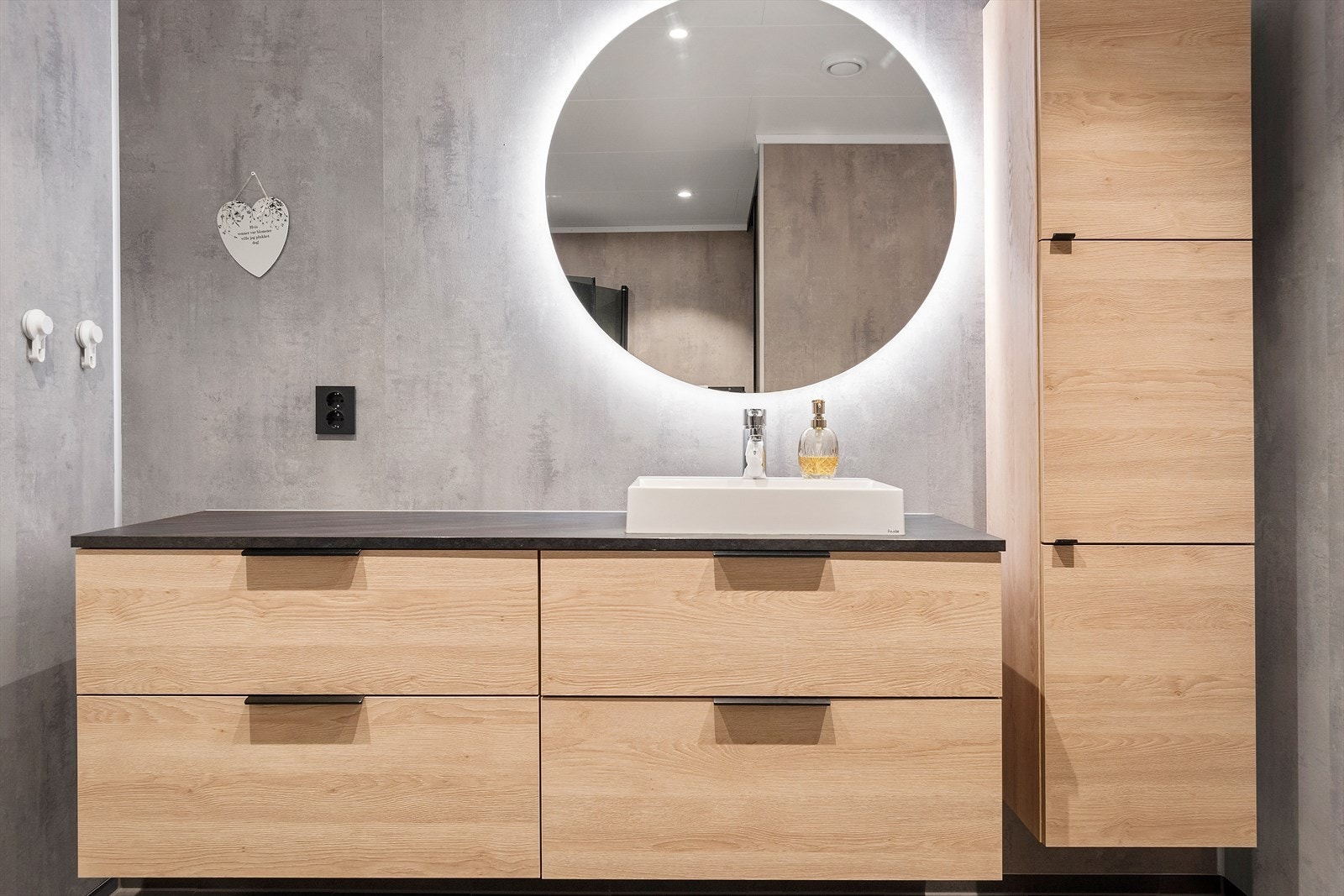 Badet har vegghengt toalett, dusjhjørne og denne flotte innredningen. Galleribilde