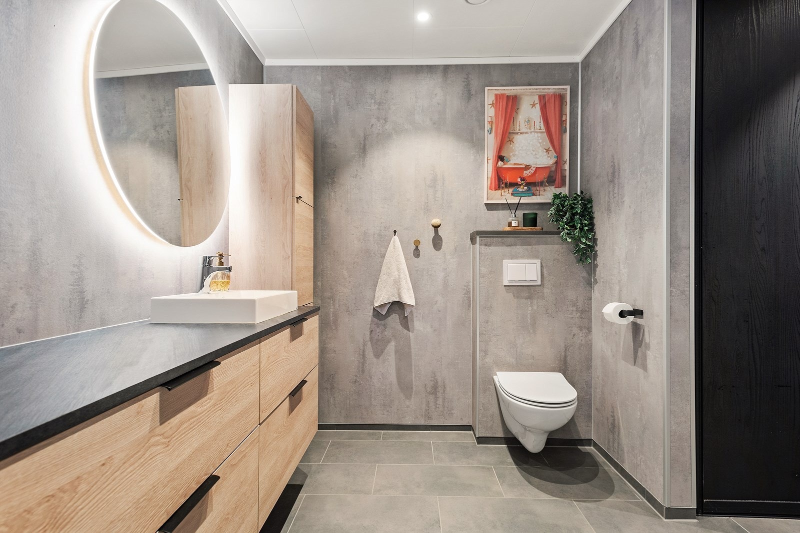 Meget stilig bad i underetasjen. Her finner du rikelig av benkeplass og oppbevaringsplass i skuffer og skap. Fliser på gulv med gulvvarme. Galleribilde