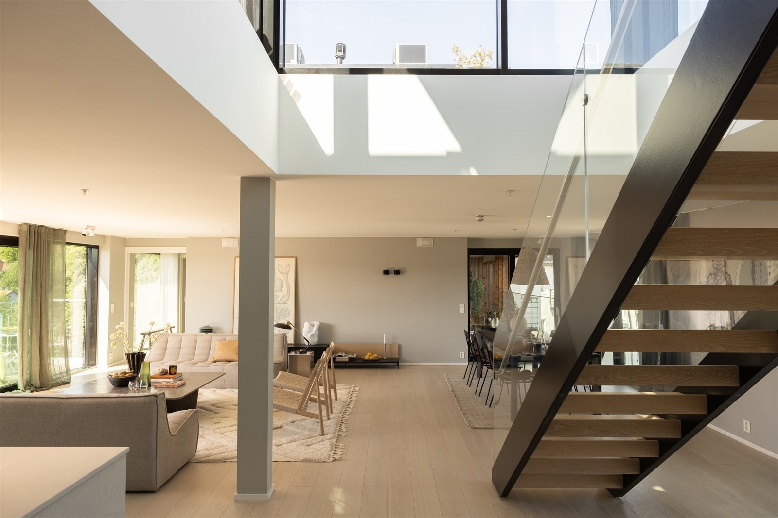 Via stilfull interntrapp med stålvanger, lakkerte trinn og glassrekkverk kommer du opp til en luftig og lys loftstue med utgang til en spektakulær takterrasse på hele ca. 90 m². Galleribilde