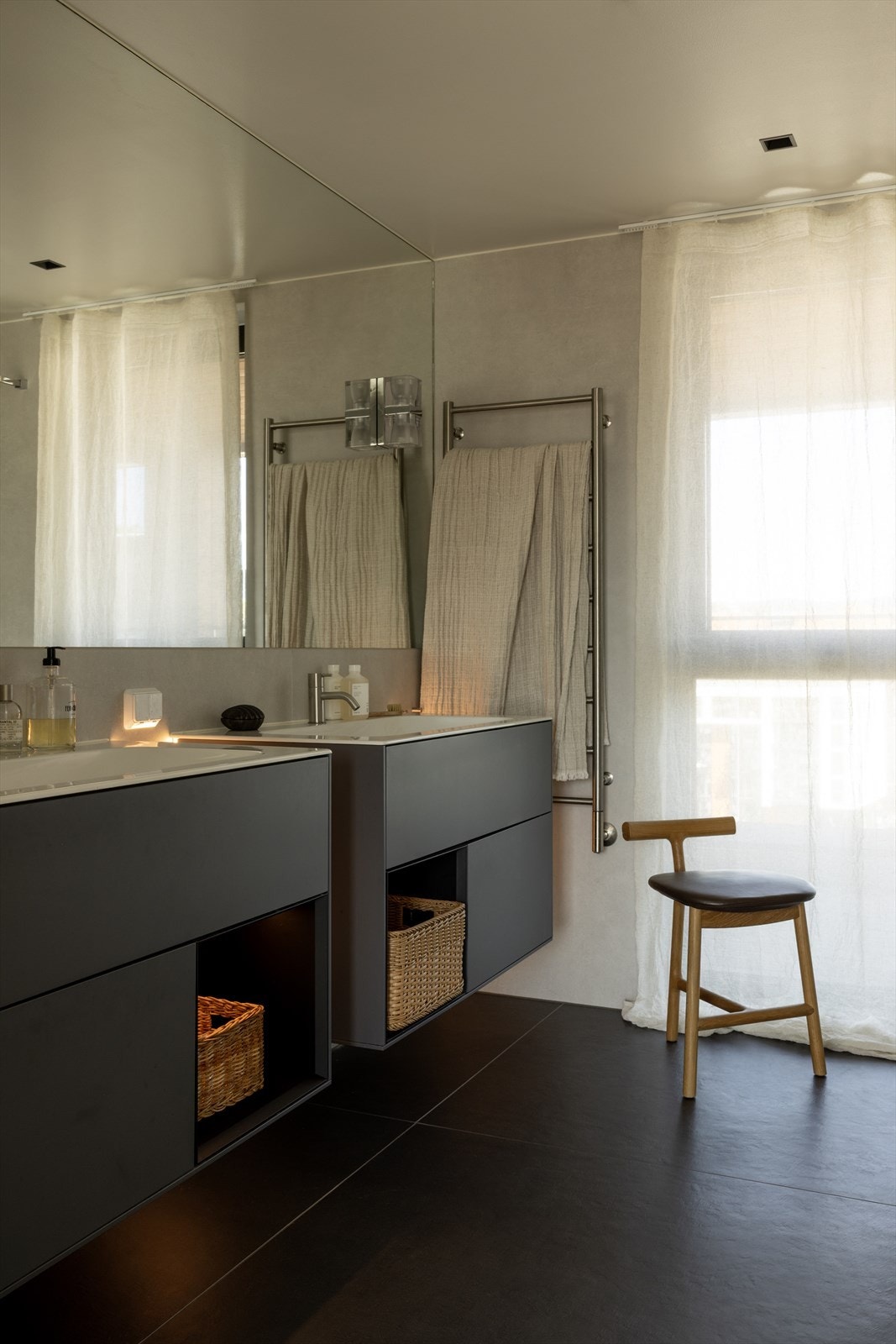 Pent flislagt masterbad med moderne innredning og dobbel servant, dusjhjørne med glassvegg, innebygde armaturer og vegghengt toalett. Elektriske varmekabler i gulv og downlights i taket gir høy komfort og god belysning. Galleribilde