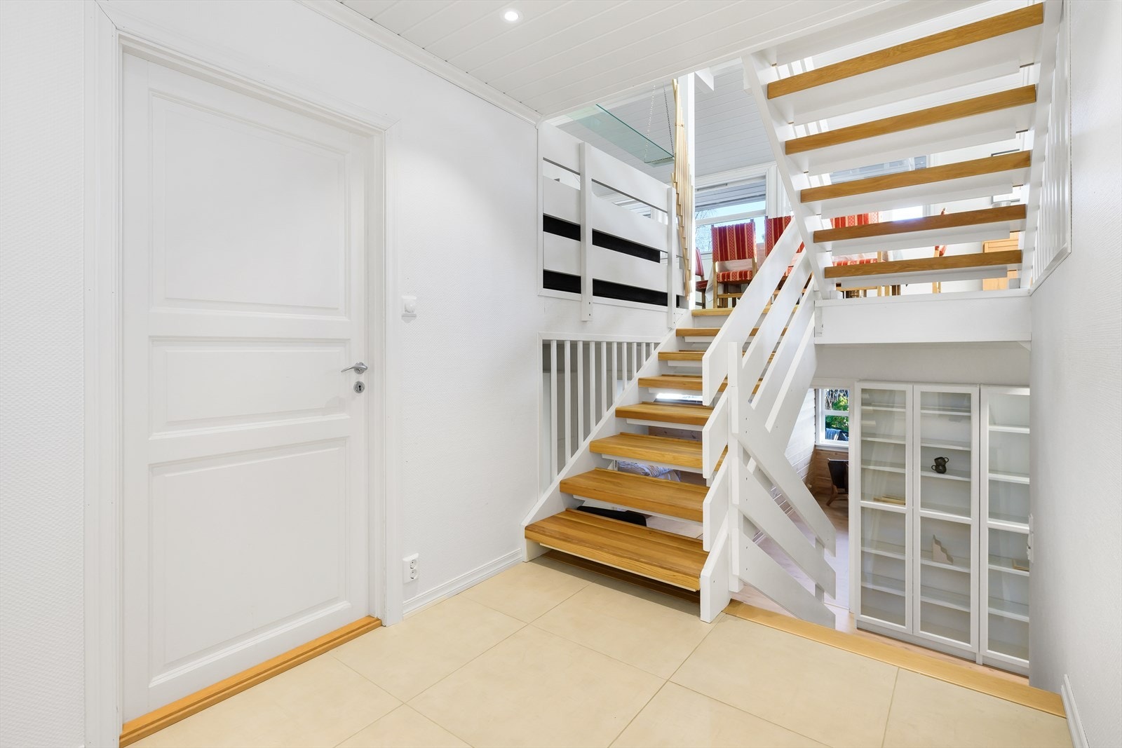 Platået i trapperommet mellom første etasje og underetasjen har flislagt gulv og inngangsdører til bodene samt egen inngang fra uteområdet. Galleribilde