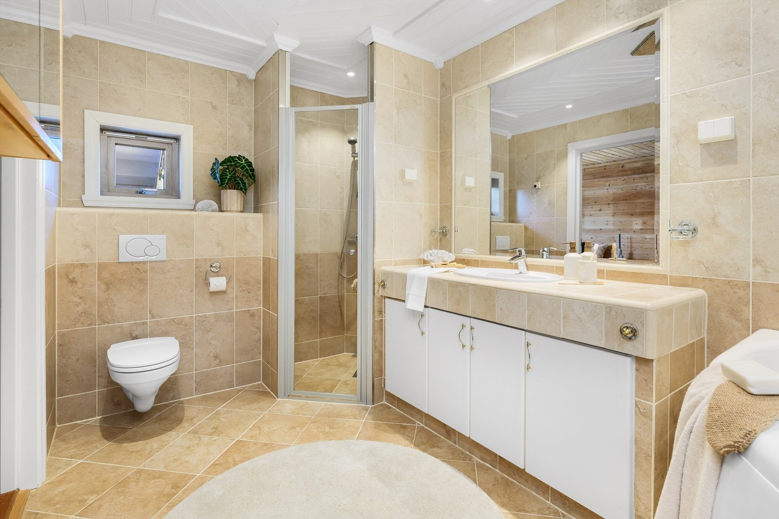 Her har en fått plass til et frittstående boblekar, eget "dusjrom" med glassdør, vegghengt toalett og en plassbygd baderomsinnredning med godt med oppbevaringsplass. Galleribilde