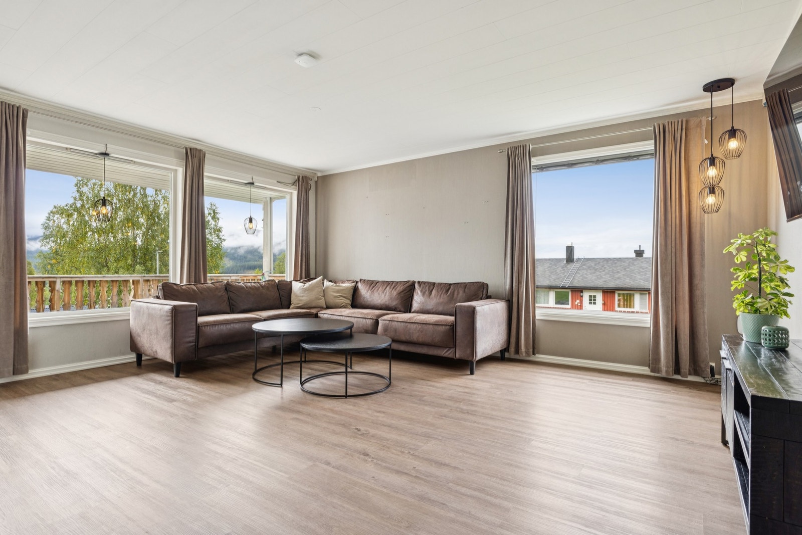 Stuen ar store vindusflater som gir flott dagslys og lun atmosfære. Galleribilde