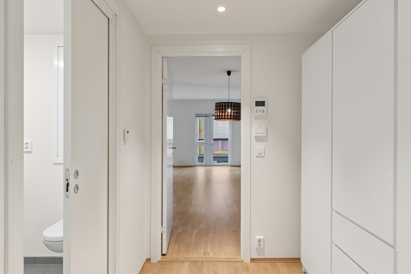 En lysmalt entré ønsker deg velkommen inn i leiligheten. Galleribilde