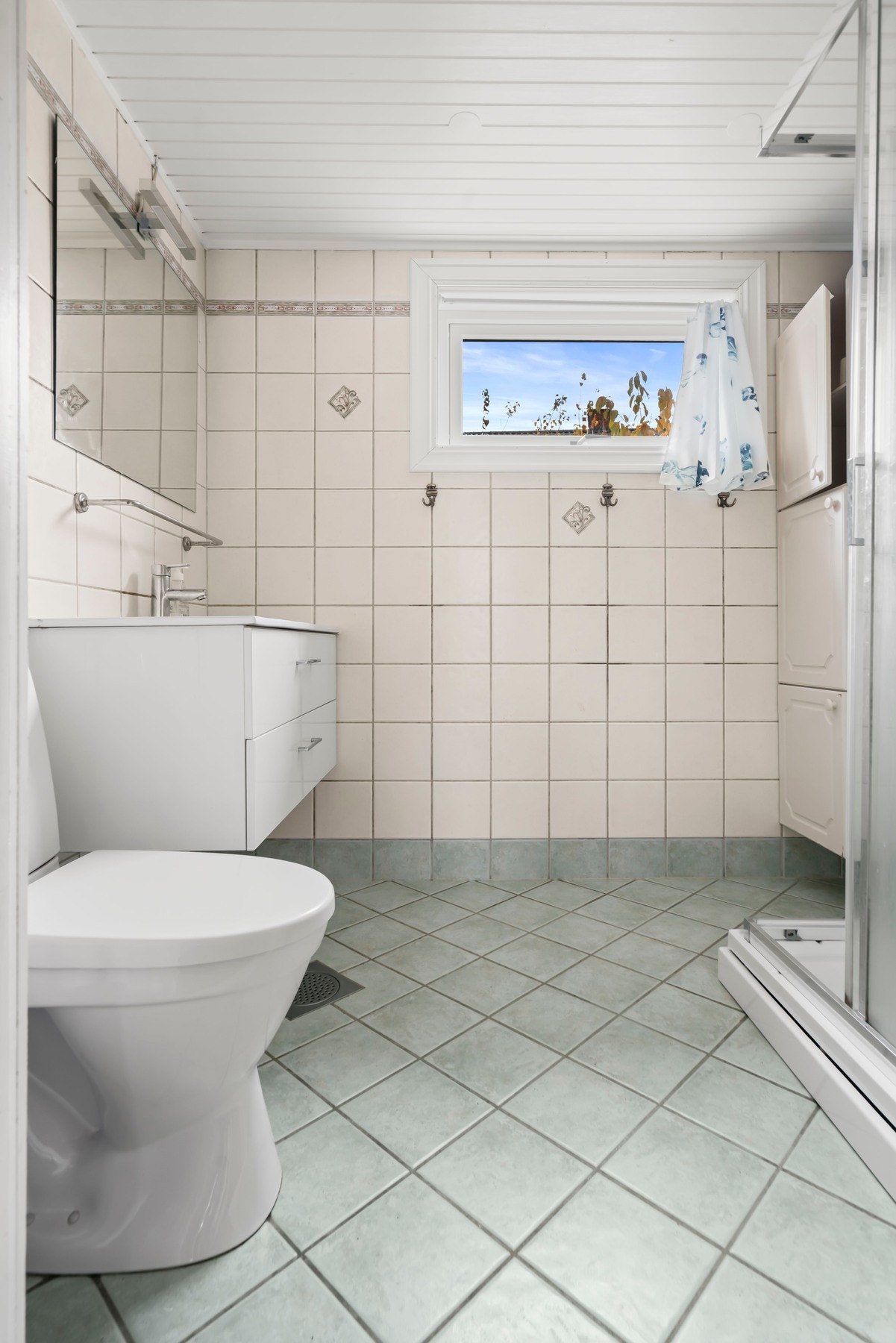 Eldre bad med dusjkabinett, toalett og servant, samt gulvvarme. Galleribilde