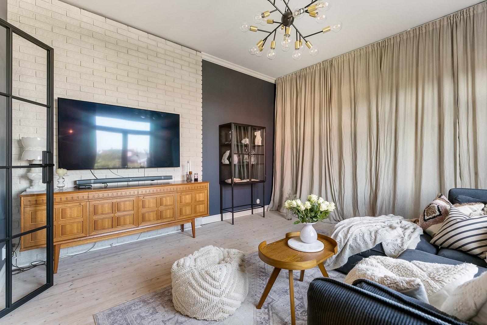 TV-stuen har fortsatt plassbyggede garderobeskap fra tidligere år i behold, skjult bak gardinene. Galleribilde