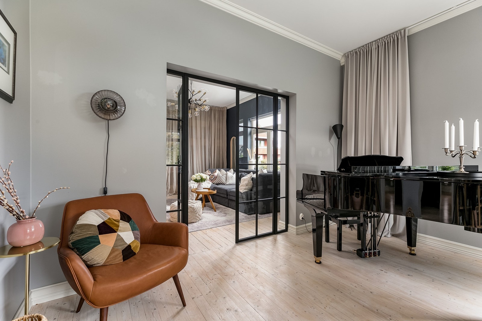 Glassvegg og gardiner gjør det mulig å ta TV-stuen umiddelbart i bruk som soverom. Galleribilde