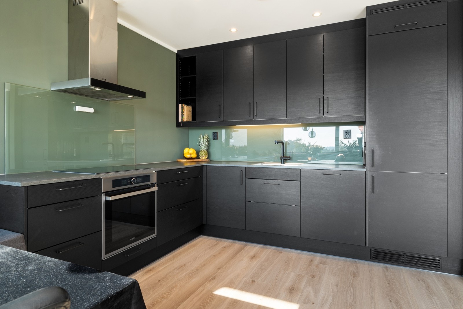 Kjøkken med takhøye overskap og integrerte hvitevarer. Galleribilde