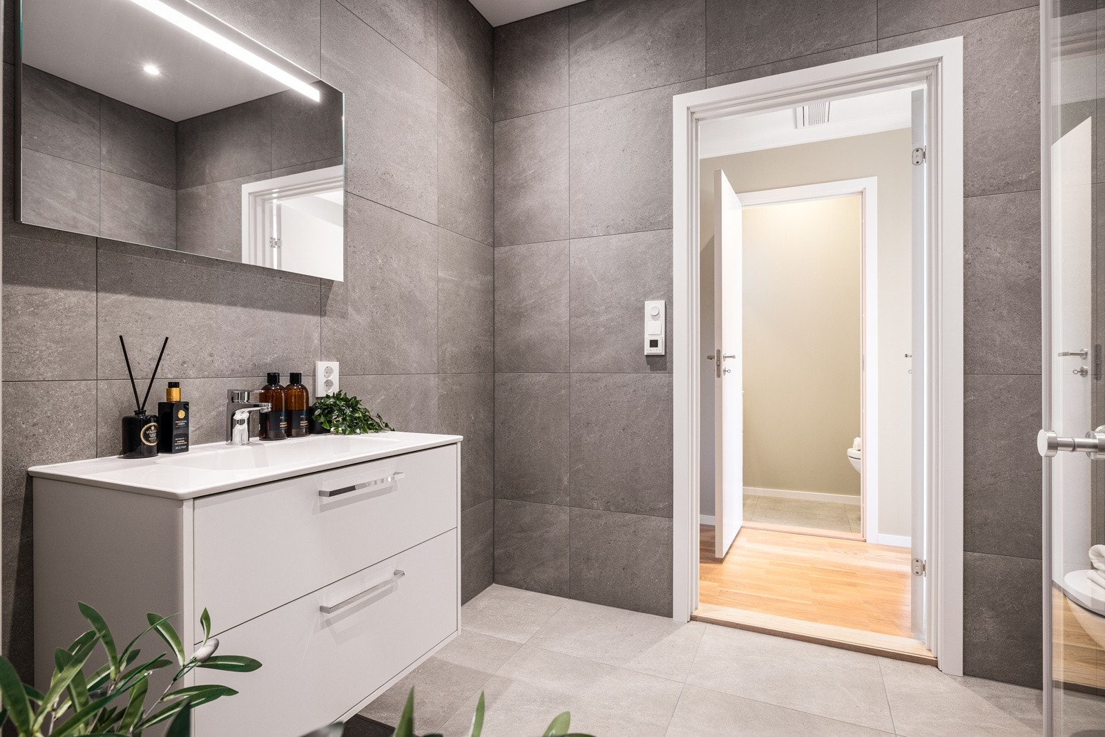 Badet har delikate fliser og baderomsinnredning med god skapplass Galleribilde