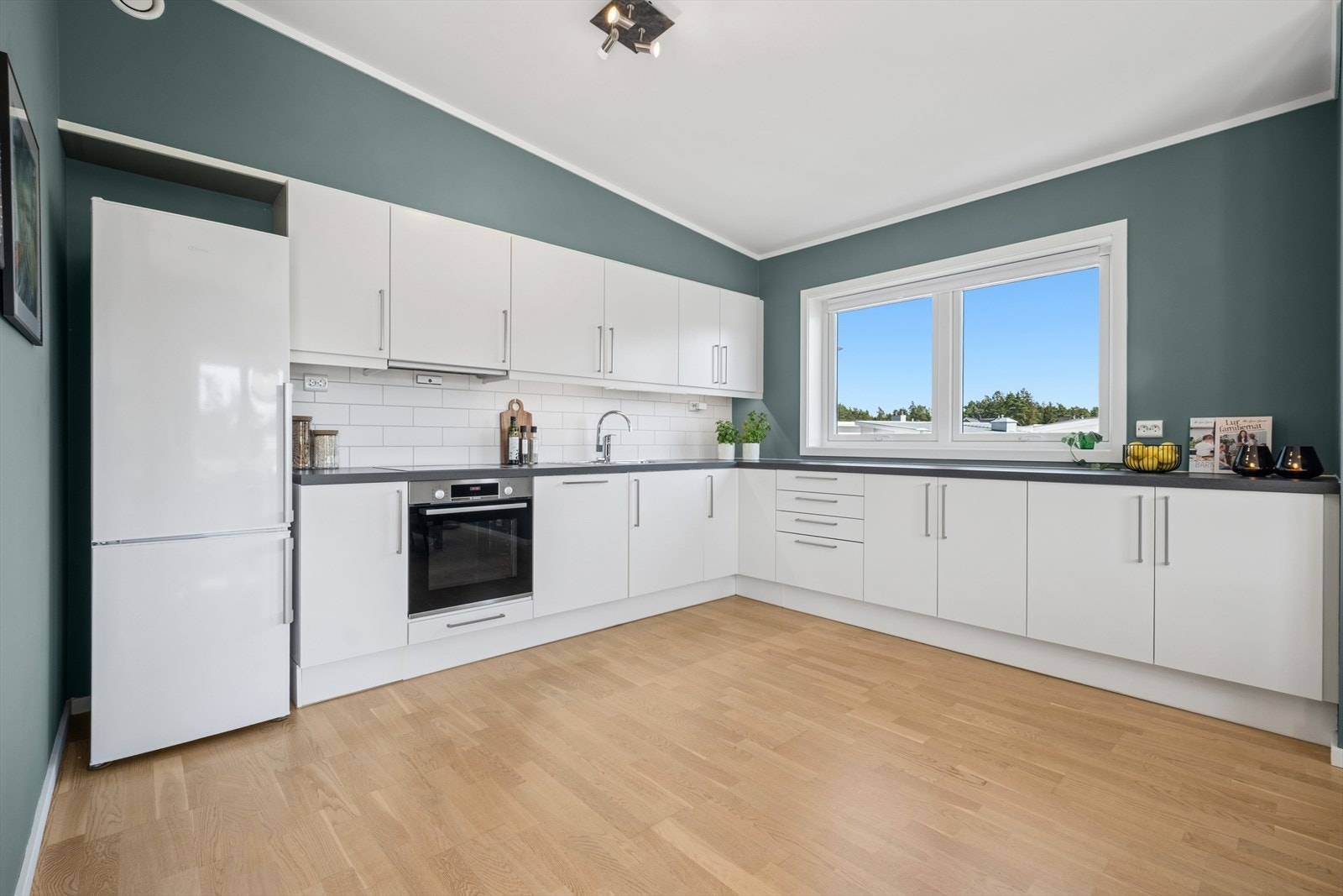 Innredningen har en stilren utførelse med hvite fronter og grå laminatbenkeplate. Galleribilde