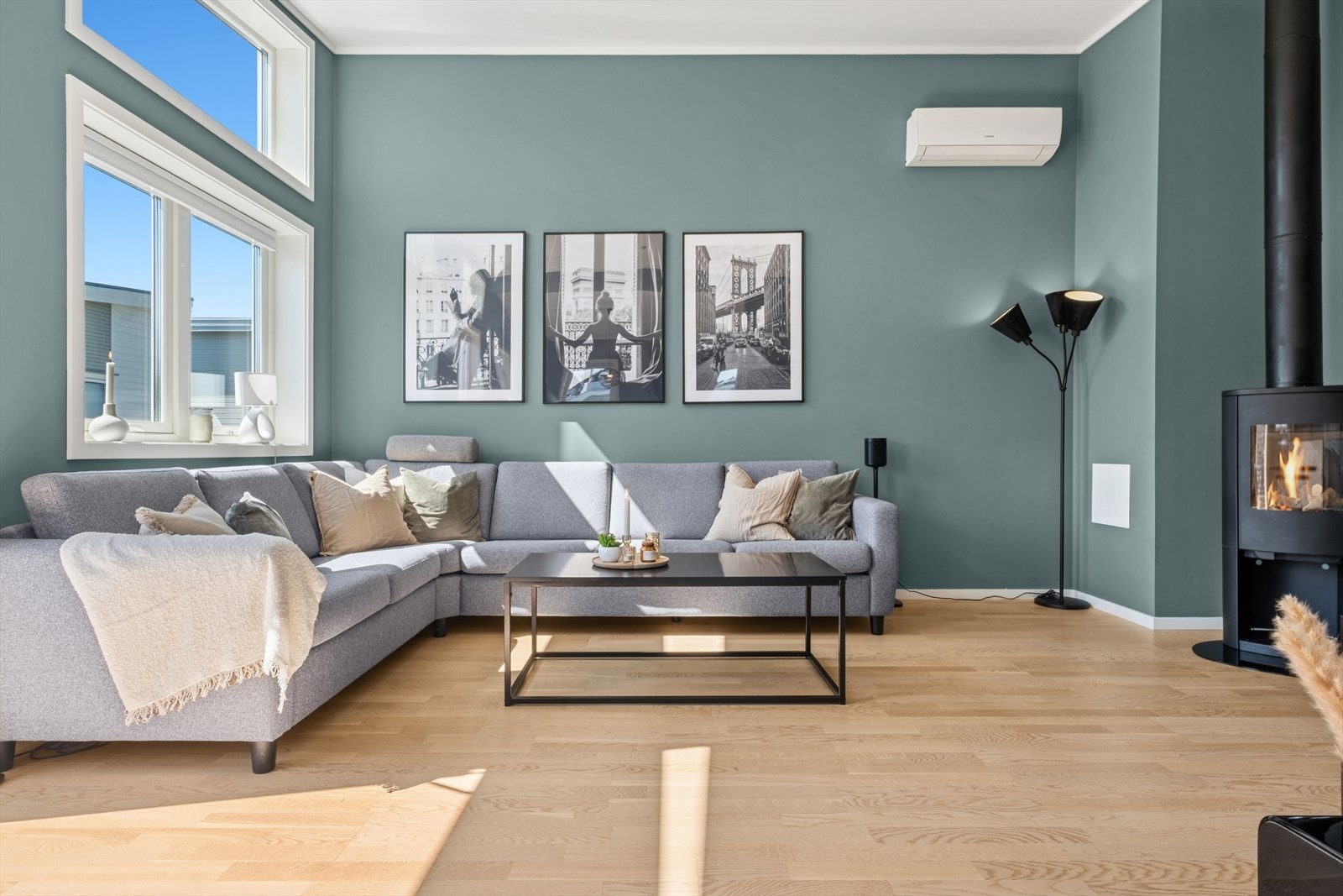 Videre beveger vi oss til stuen - som er malt i en delikat blågrønn tone og har mange store vindusflater. Galleribilde