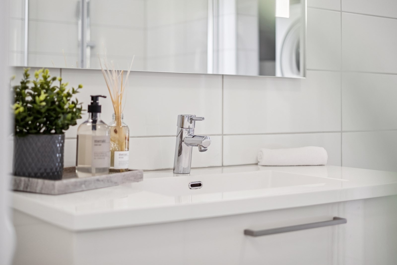 Badet er utstyrt med en pen servantinnredning og speil med integrert belysning. Galleribilde