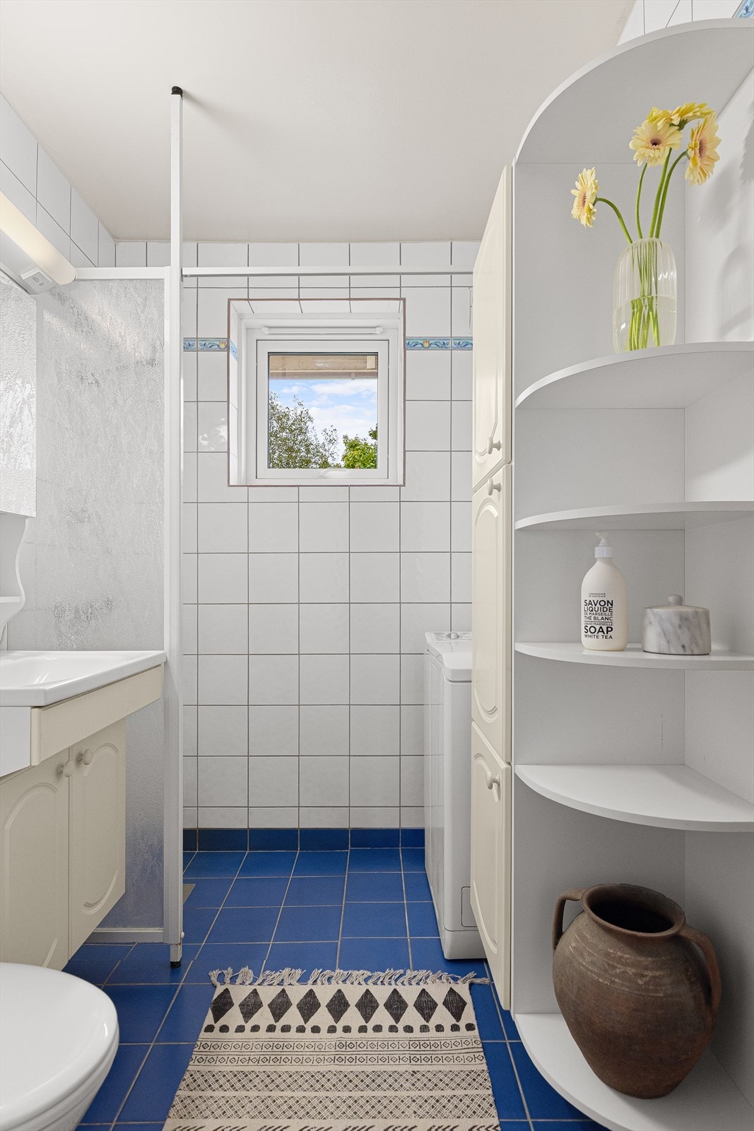 Flislagt bad med gulvvarme. Badet har godt med lagringsplass i veggskap og servantskap Galleribilde