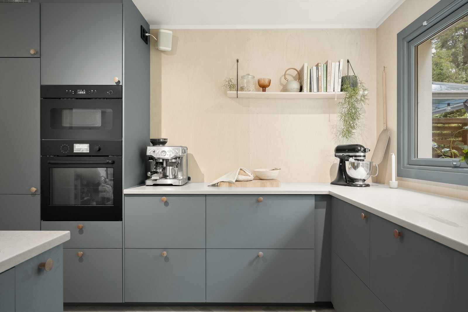 Kjøkkenet har en tilbaketrukket og praktisk plassering. Her er det en stilren kjøkkeninnredning fra Ikea med glatte fronter, kompositt benkeplate og underlimt vask i kompositt. Galleribilde