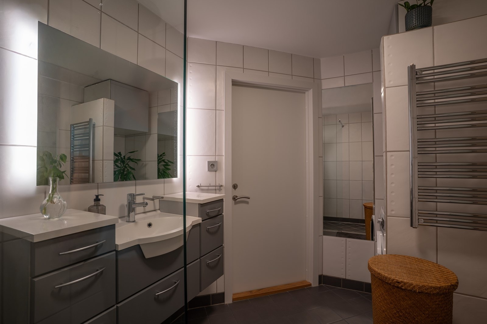 Badet inneholder dusjnisje med glassvegg, vegghengt toalett, servantskap og vaskemaskin. Galleribilde