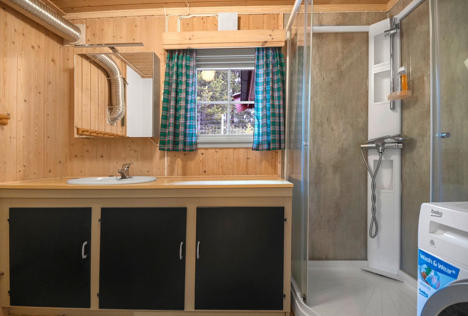 Bad med dusjkabinett og innredning med underskap og nedfelt servant i benk. Opplegg til vaskemaskin Galleribilde