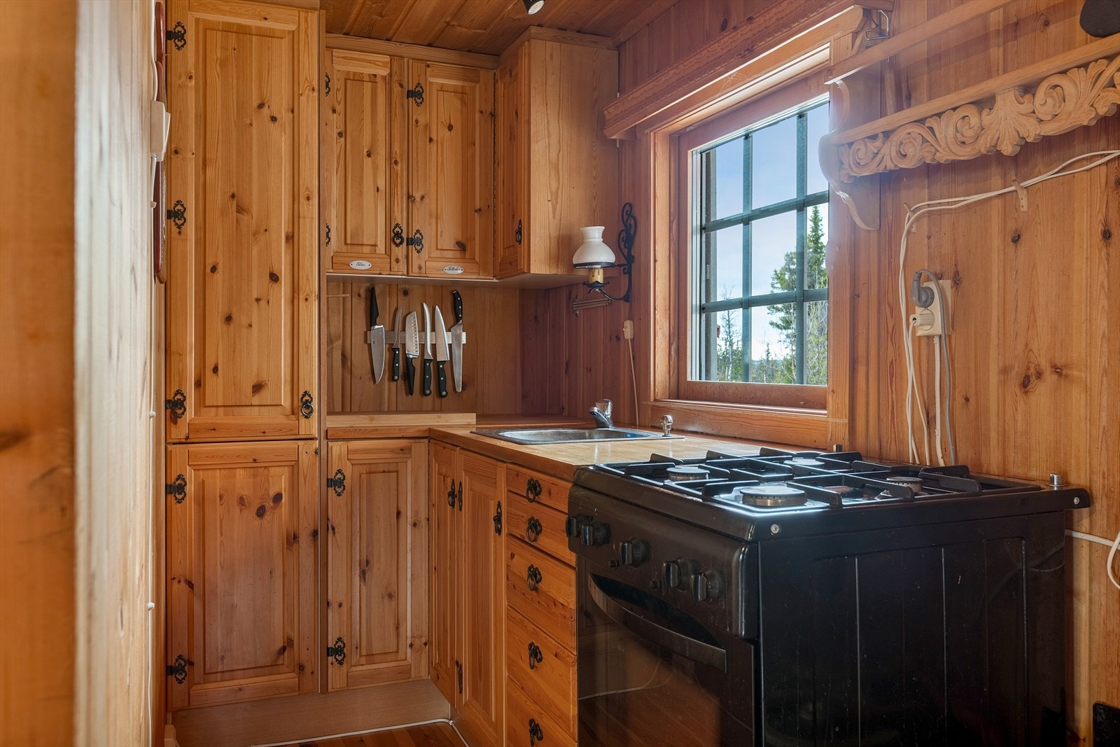 Kjøkkeninnredning i folierte plater og profilerte heltre fronter med over- og underskap, samt høyskap som har bra med oppbevaringsplass. Heltre benkeplate og oppvaskkum av stål. Galleribilde