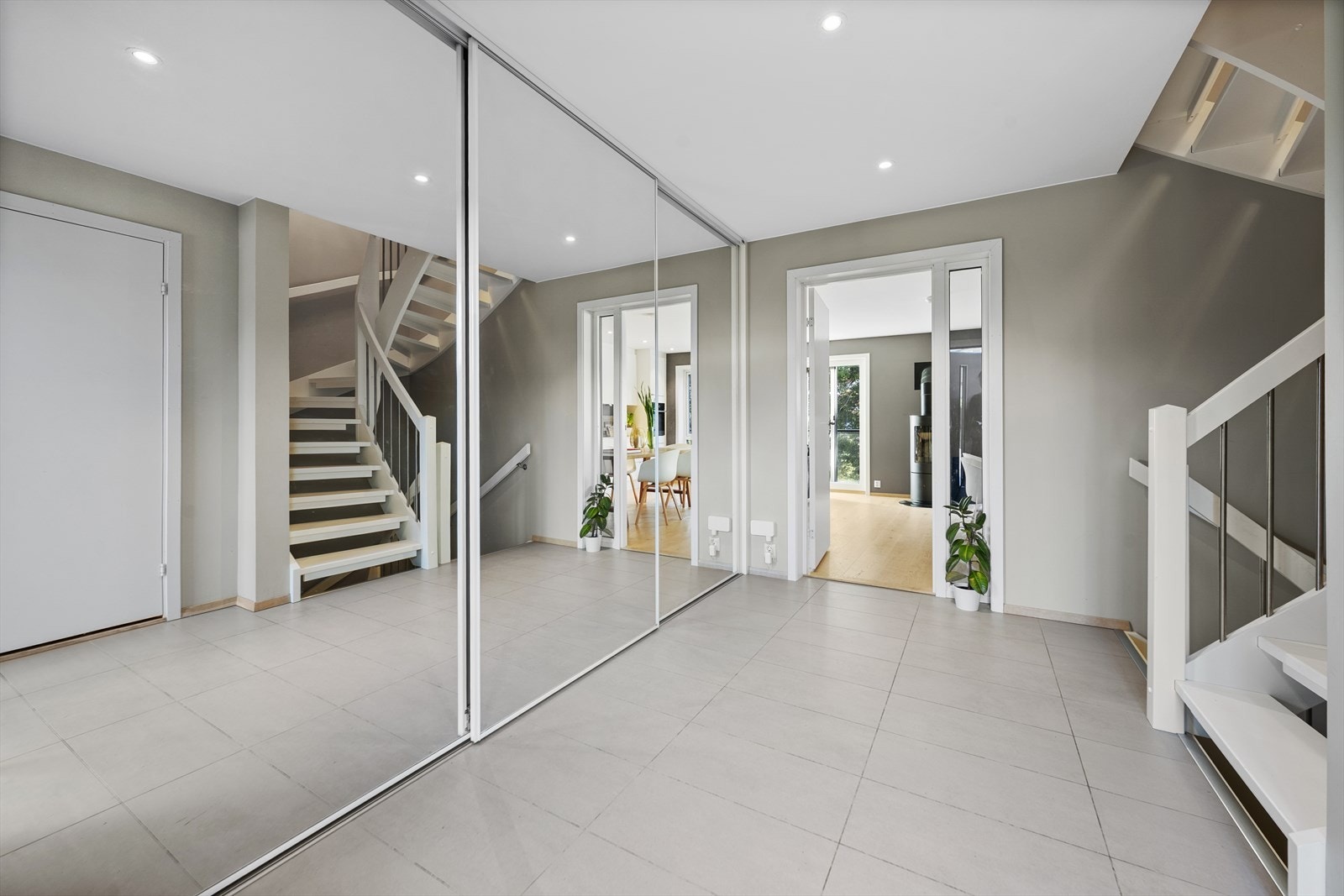 Entréen er utstyrt med stor skyvedørsgarderobe med speilfronter. Fra entré har du videre tilgang til bod, stue, kjøkken og trapp til underetasjen og 2. etasje Galleribilde