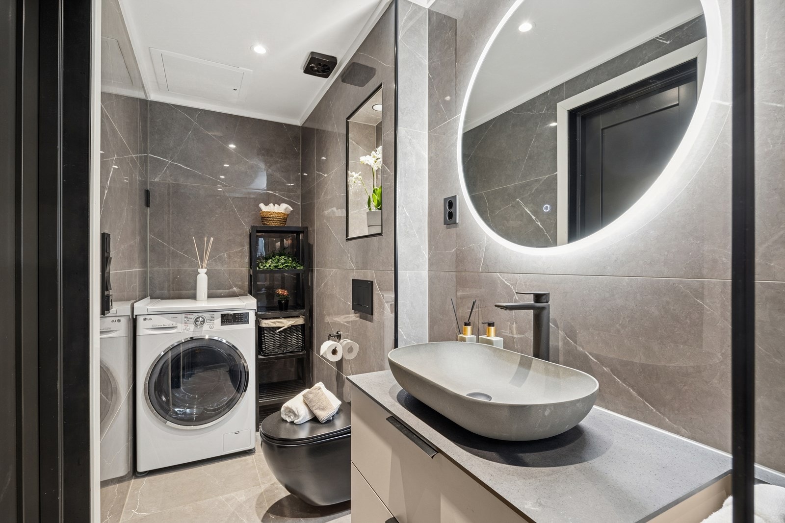 Delikat, flislagt baderom fra 2022 med varmekabler i gulvet, innfelte downlights i himlingen og opplegg for vaskemaskin og tørketrommel. Galleribilde