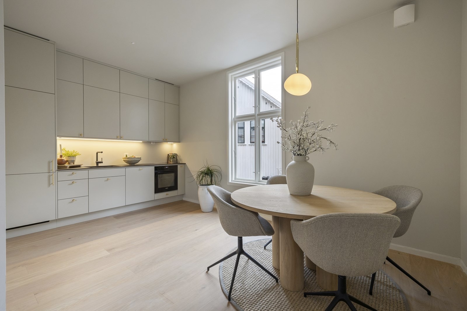 Åpen stue- og kjøkkenløsning med plass for spisebord og sofagruppe. Galleribilde