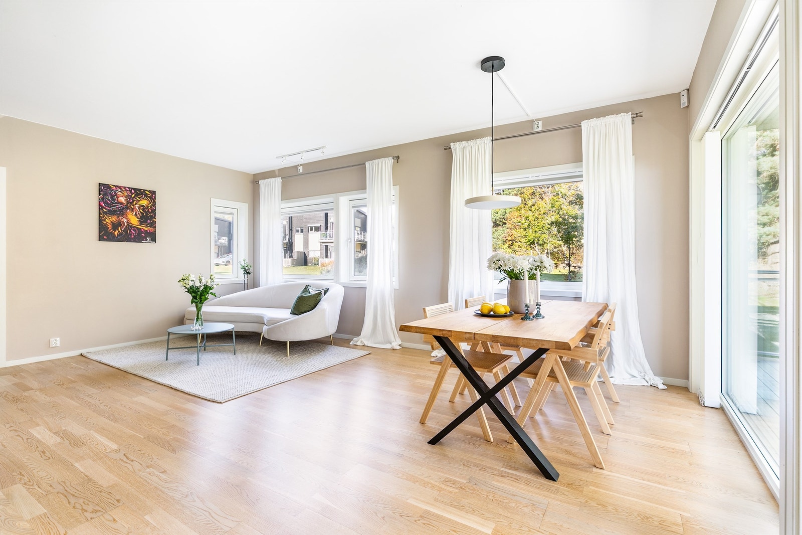 En rekke vinduer med til dels store flater gjør stuen lys og slipper solen inn på morgenen og formiddagene i årets varme måneder. Galleribilde