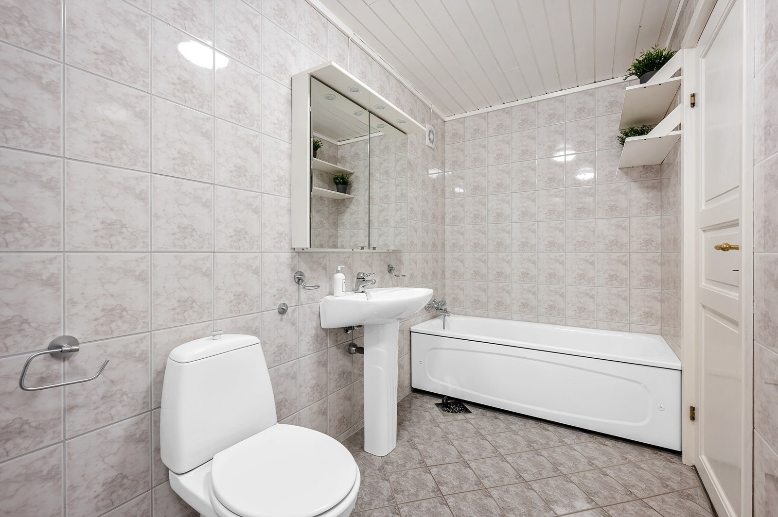 Badet er innredet med dusjhjørne, toalett, servant og badekar. Galleribilde