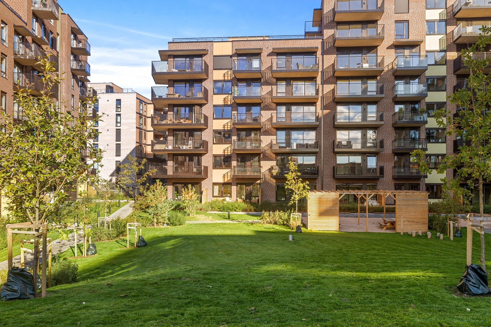 Pent opparbeidet gårdsrom med gangstier, pergola, sittegrupper og beplantning. Galleribilde