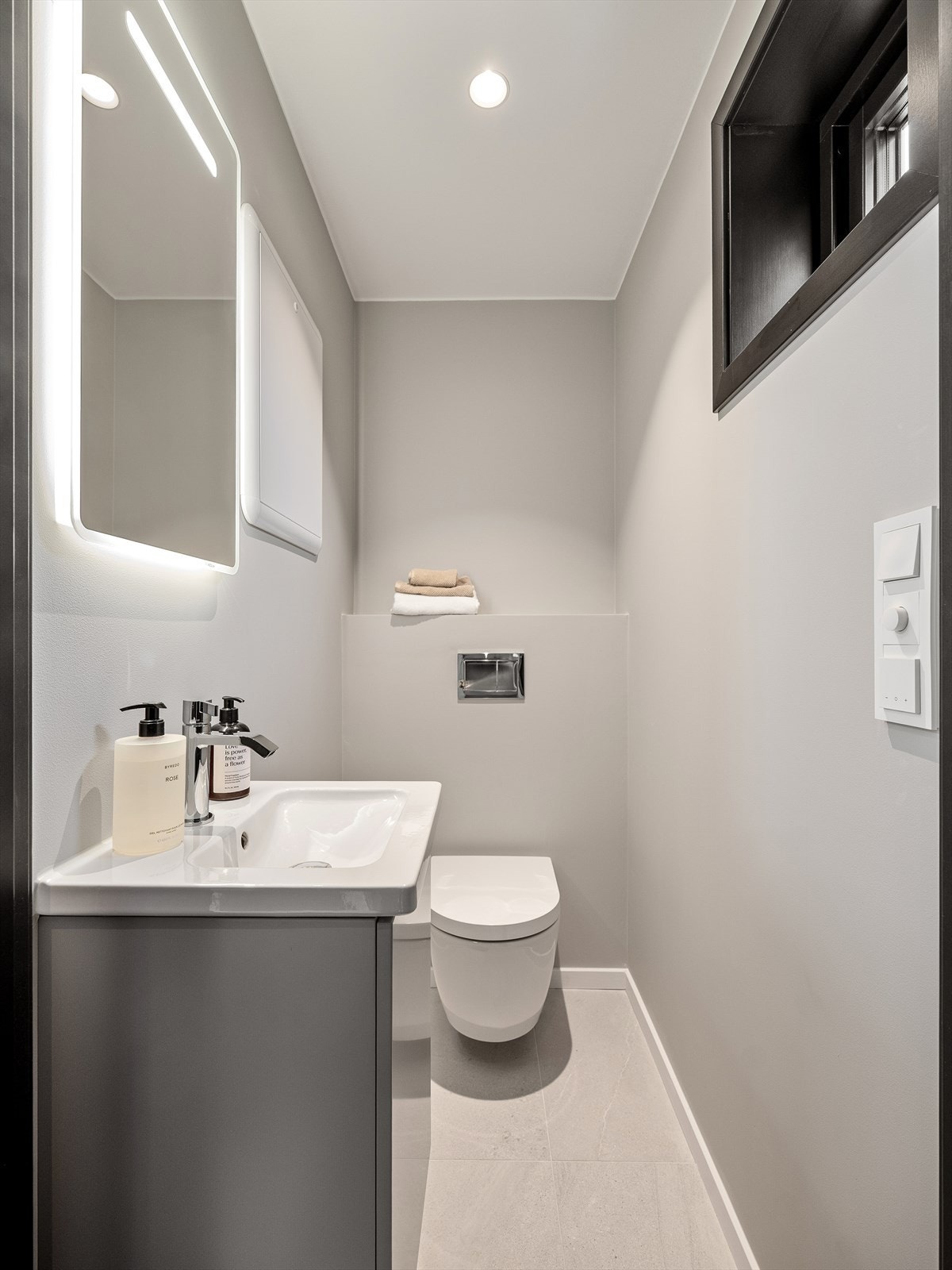 Gjestetoalett i 1. etasje med flislagt gulv og malte veggflater. Varmekabler i gulv og downlights i himling Galleribilde