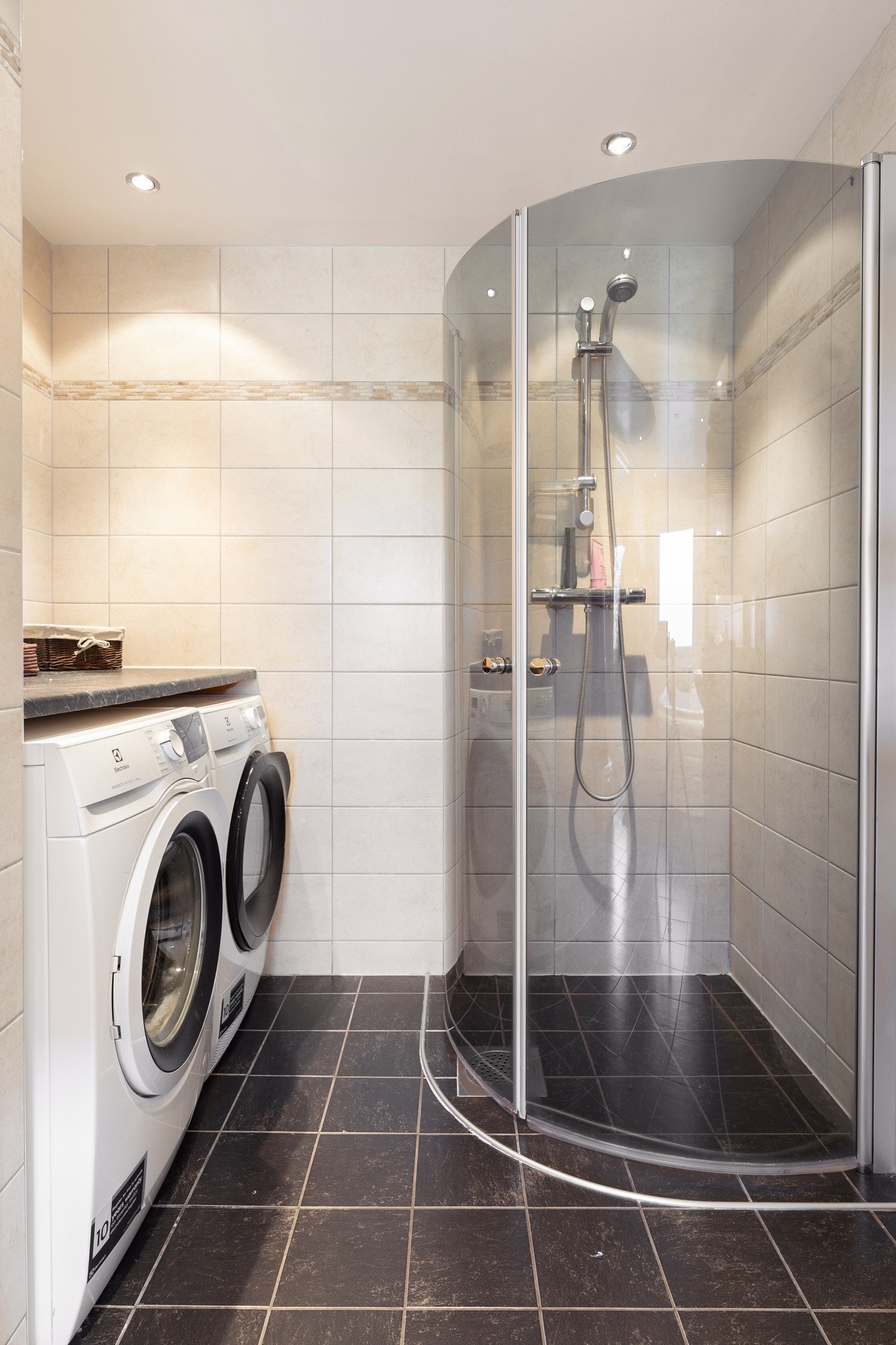 Det er opplegg for vaskemaskin og tørketrommel. Benkeplate av laminat over vaskemaskin og tørketrommel. Galleribilde