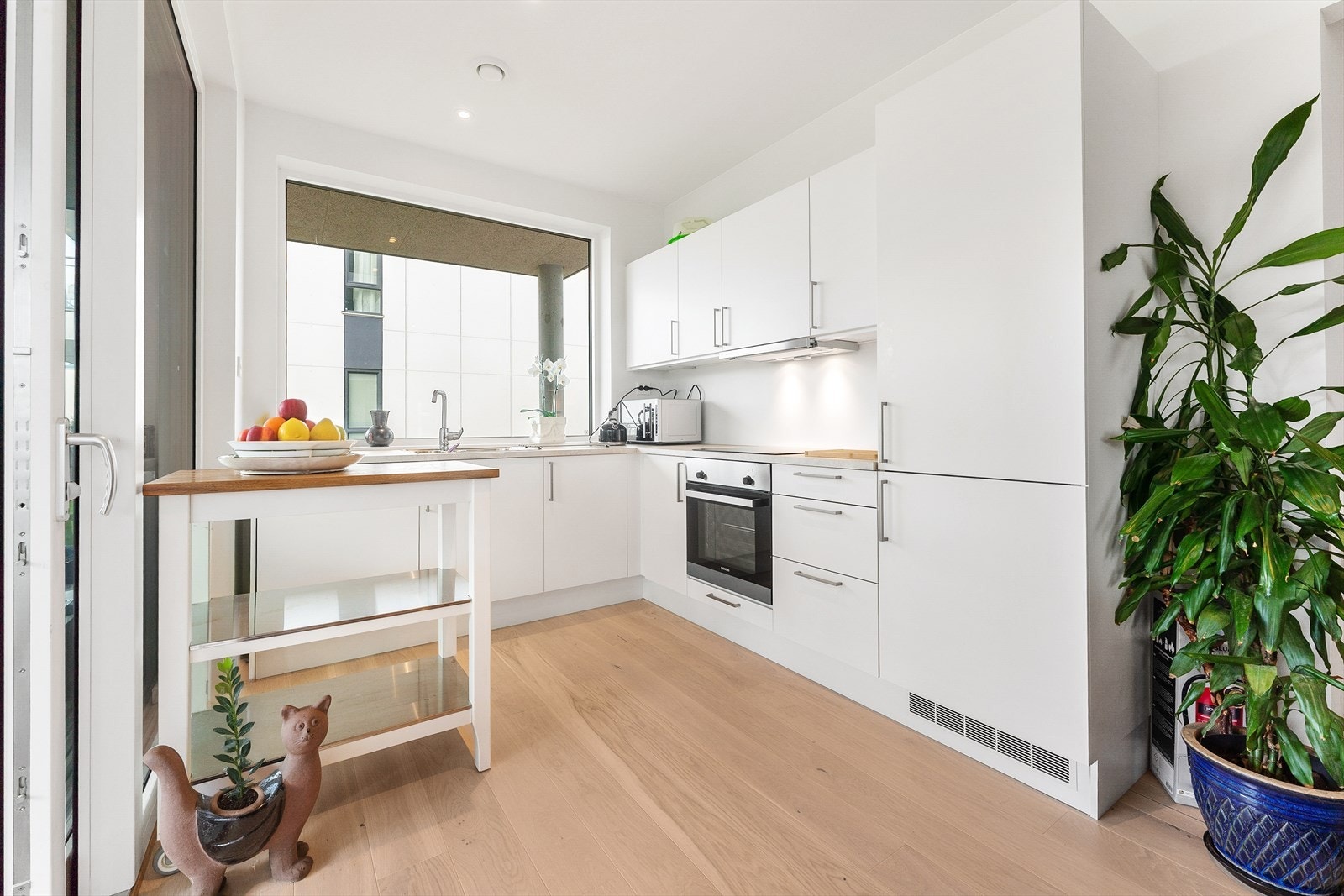 Lyst og fint kjøkken med integrerte kvitevarer Galleribilde