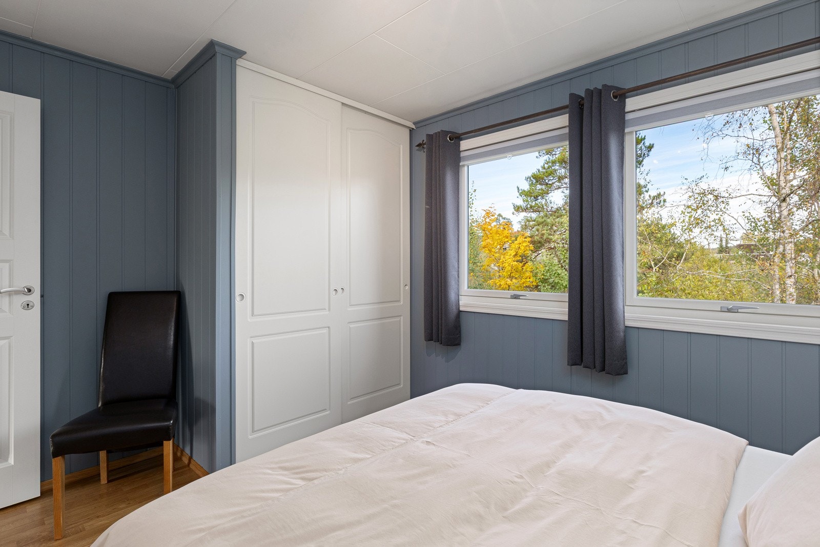 Lyst rom med store vinduer og rolige farger. Galleribilde