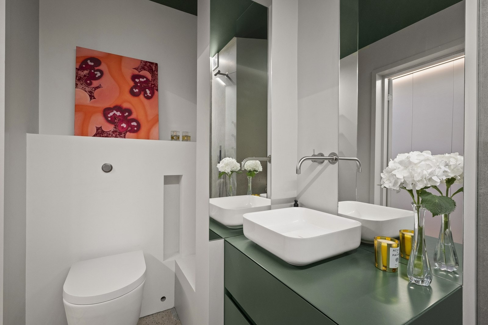 Badet er utstyrt med baderomsmøbel og servant i Ceramilux fra Antonio Lupi, veggmontert toalett, dusj m/glassvegg, speil og elektrisk håndklevarmer. Integrerte armaturer i rustfritt stål fra Vola. Galleribilde