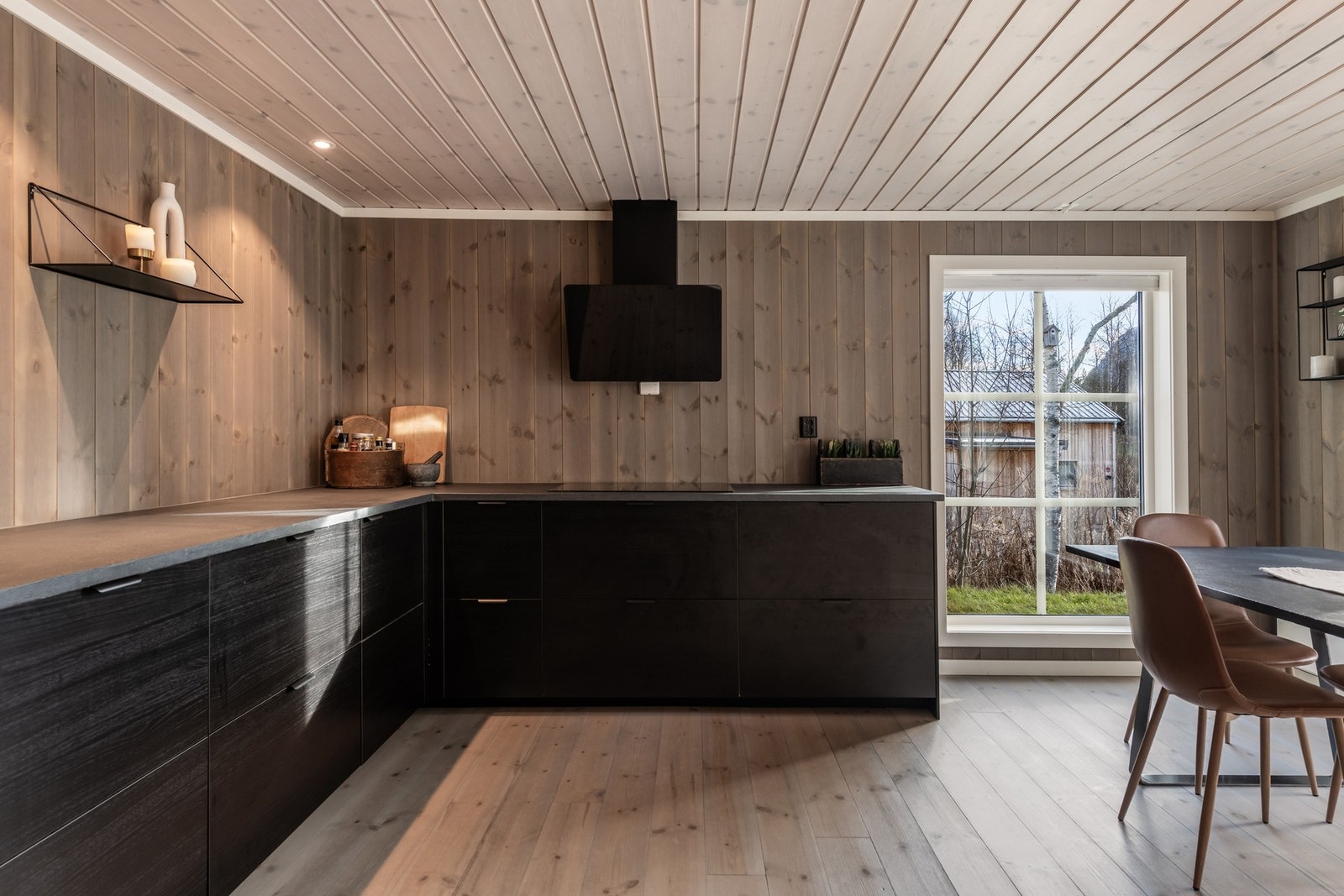 Kjøkkenet har en mørk og lun farge på fronter og benkeplate. Galleribilde