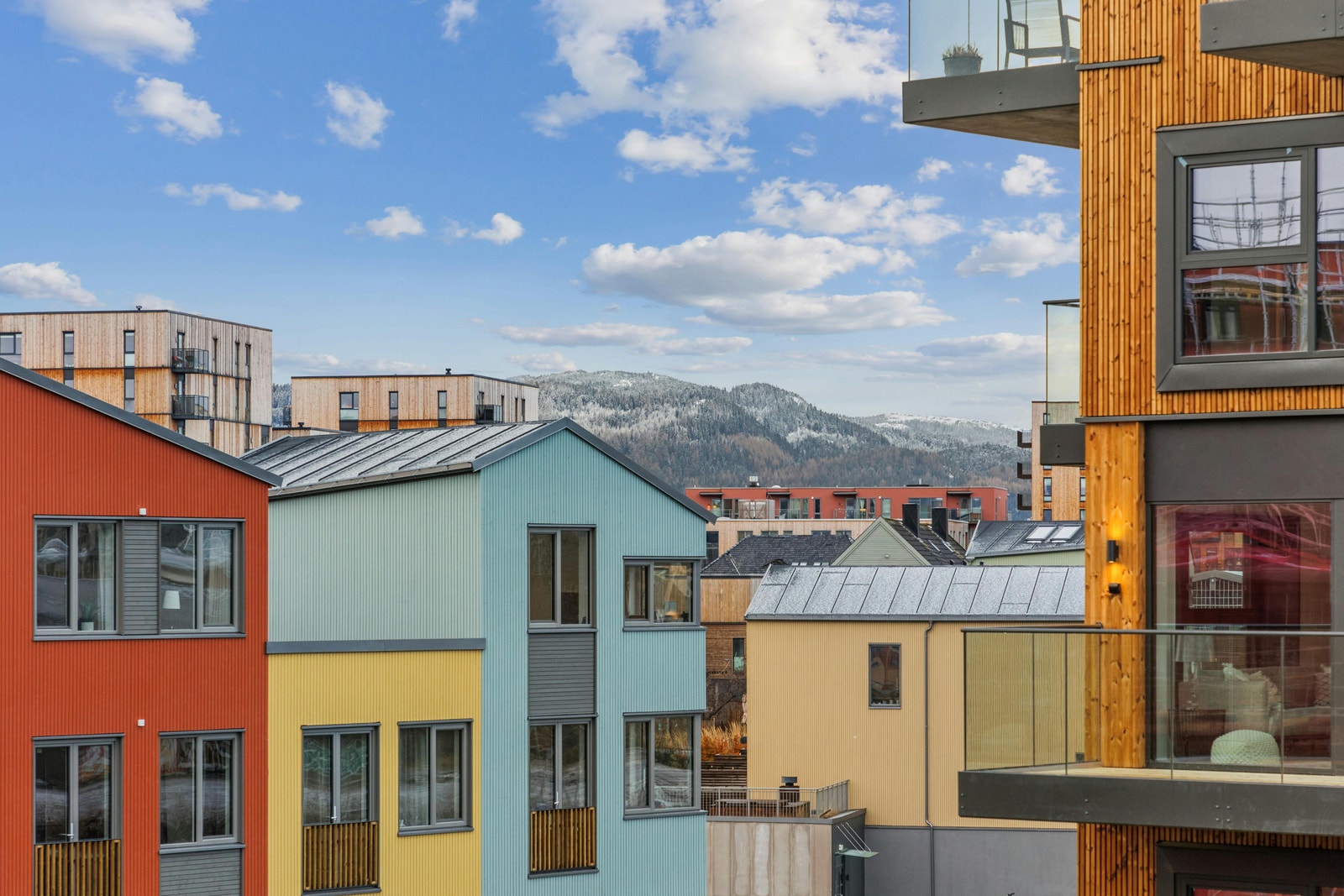 Utsikt fra balkong. Boligen er omgitt av moderne og fargerike boliger. Galleribilde