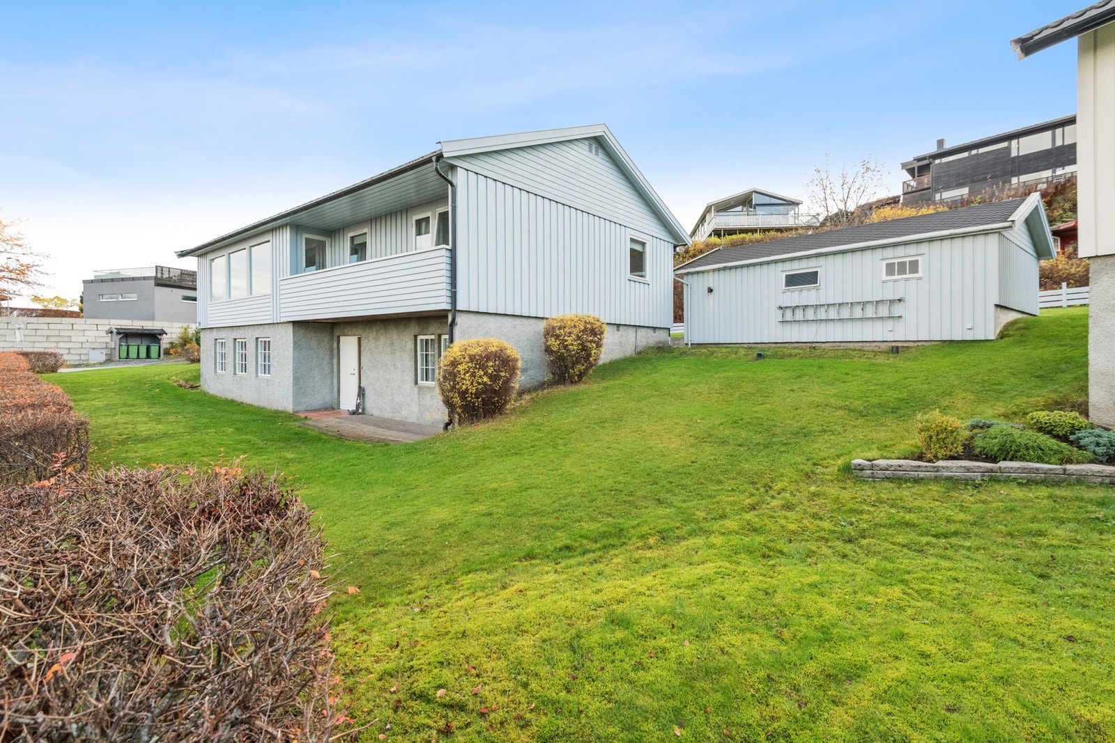 Boligen har en romslig hage som er beplantet med plen og prydbusker. Galleribilde