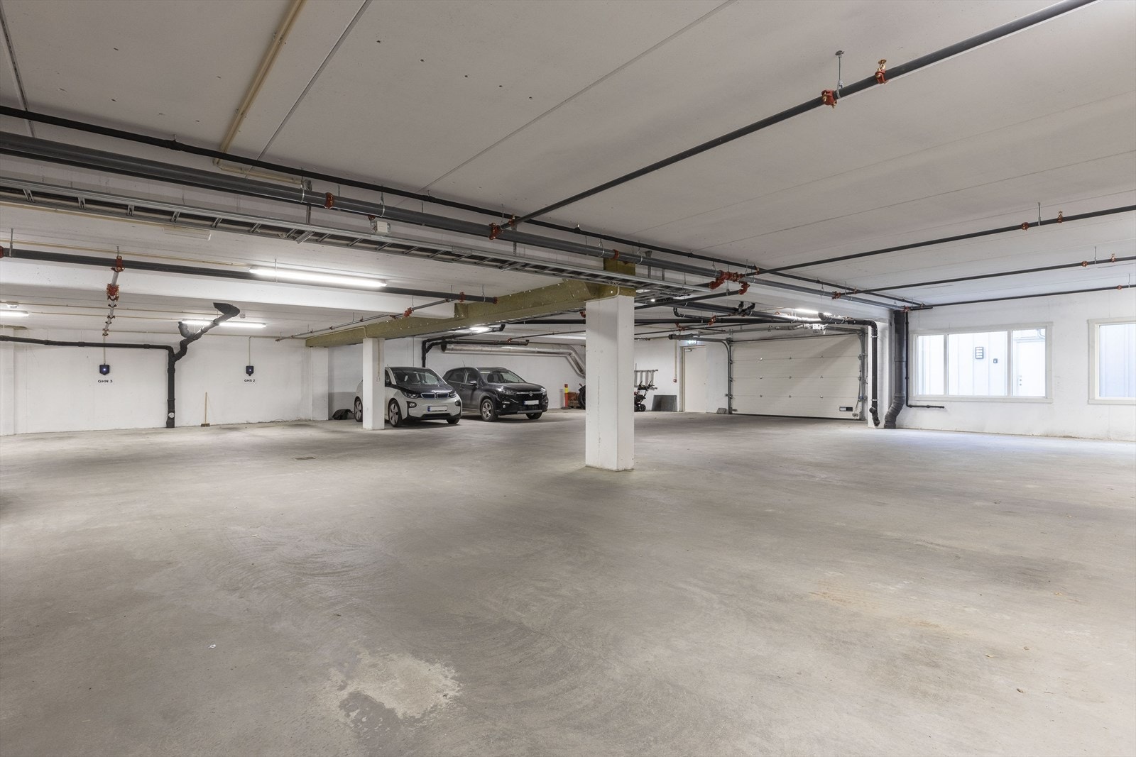 Biloppstillingsplass med el-bil lader i felles garasjekjeller Galleribilde