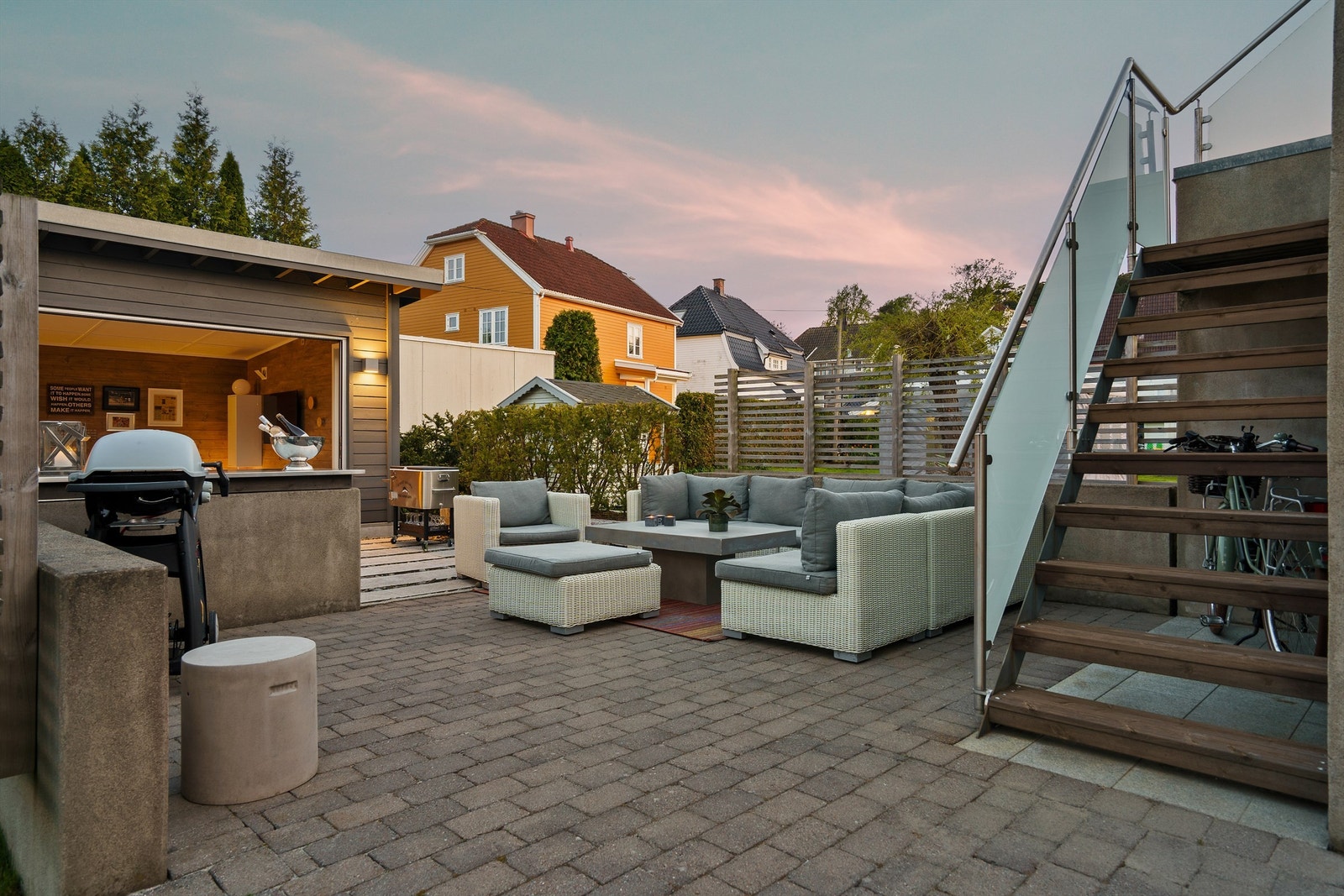 Lyse sommerkvelder i hagen er noe å se frem til i årets øvrige tider. Den skjermede uteplassen er også et fint sted for hygge rundt bålpannen vinterstid. Galleribilde