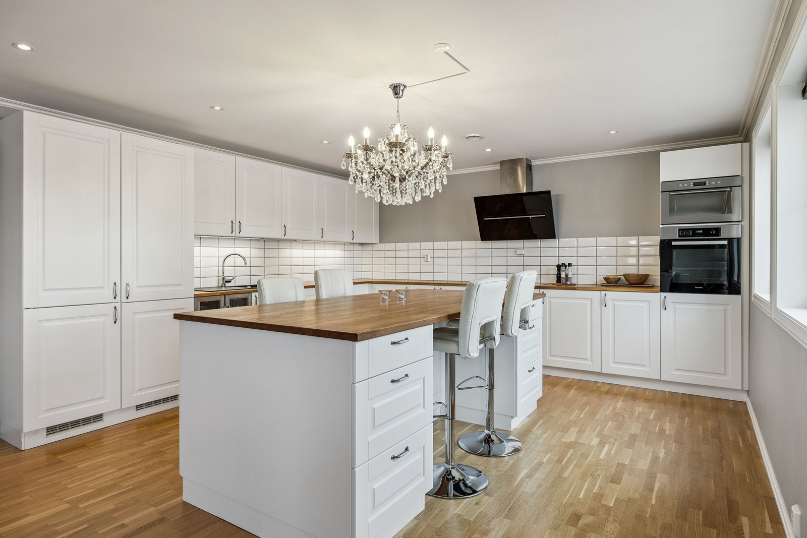 Hvitprofilert kjøkkeninnredning fra Kvik.
Heltre benkeplate i eik.
Integrerte hvitevarer som komfyr, mikroovn, oppvaskmaskin,
induksjonstopp og to kjøleskap og fryser.
Komfyr, oppvaskmasin og induksjonstopp er fra Miele. Galleribilde