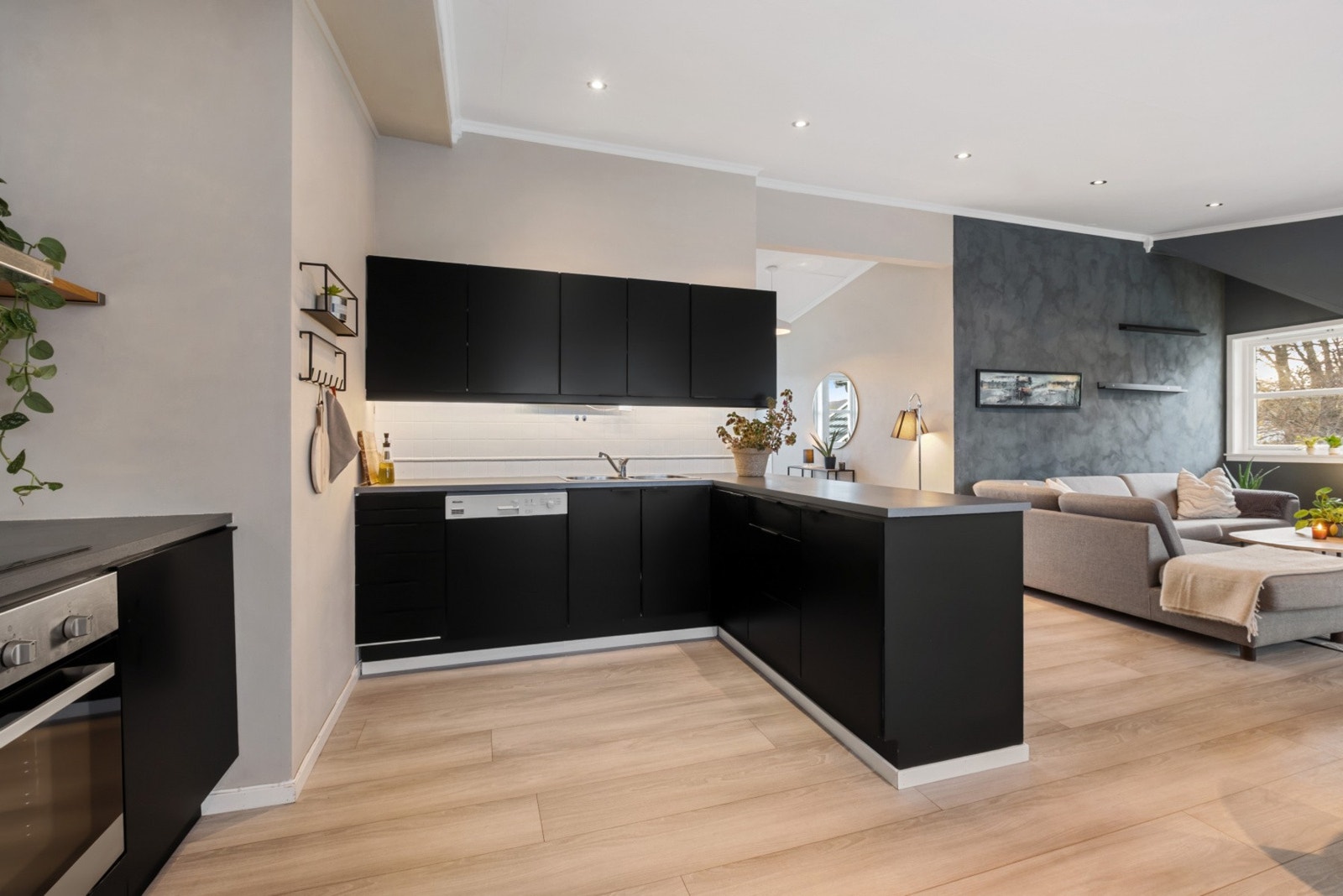 Kjøkkenet har folierte sorte kjøkkenfronter og benkeplate i laminat. Galleribilde