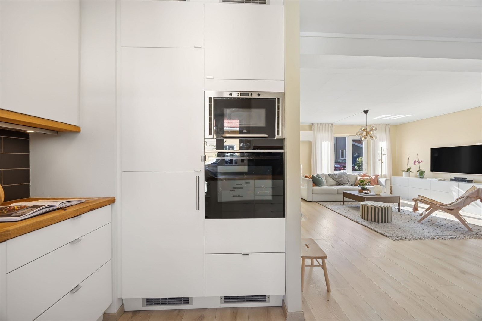 Hvitevarene medfølger salget. Kjøkkenet har avtrekk via mekanisk avtrekksanlegg i boenheten, og den delvis åpne løsningen mot stuen gir en praktisk og sosial planløsning. Galleribilde