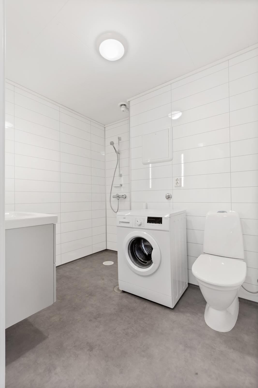 Pent nyoppusset bad med opplegg til vaskemaskin, dusjhjørne, wc og servant med skap. Galleribilde