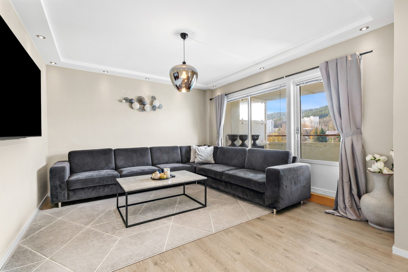 Lys og innbydende stue med laminatgulv fra 2023 og slette, lysmalte vegger Galleribilde