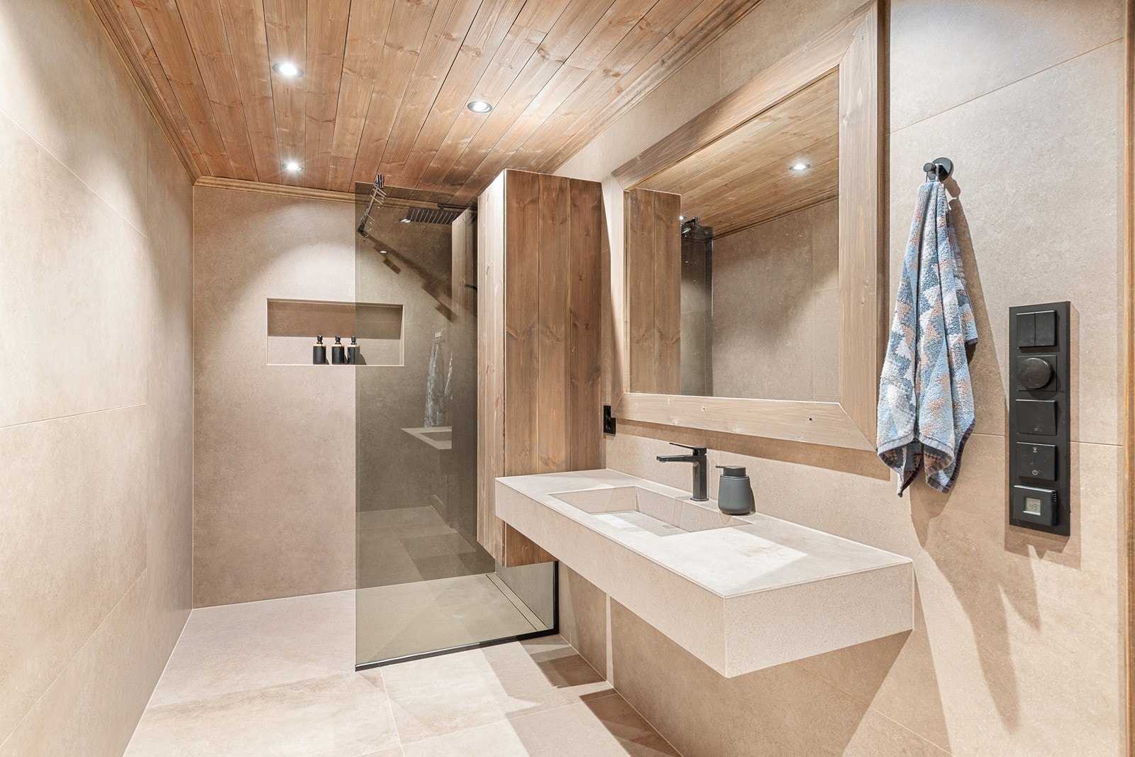 Lekkert bad med flislagte gulv og vegger. Servanten er plassbygd og flislagt. Badet er utstyrt med toalett og dusjsone med glassvegg. Galleribilde