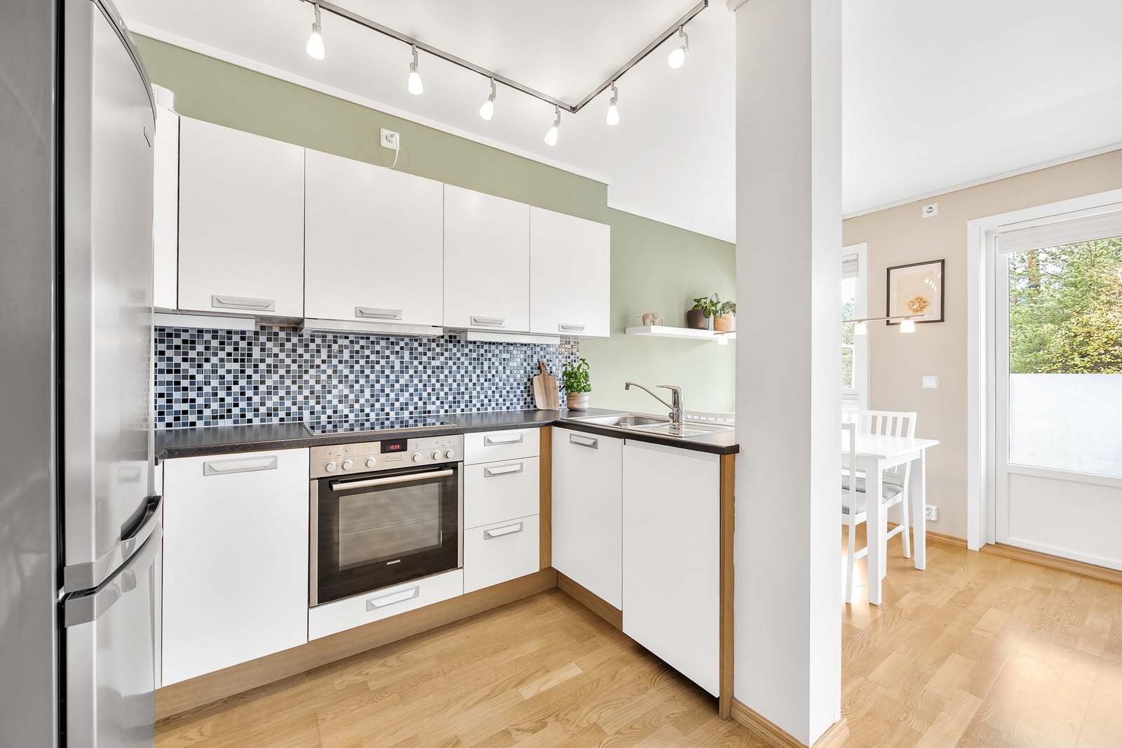 Kjøkken fra byggeår innredet med glatte fronter og godt med skapplass og benkeplass for matlagingen. Galleribilde